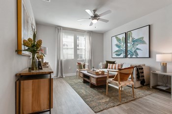 Living room with ceiling fan and hardwood flooring at Alivia Apartments in Whittier CA
